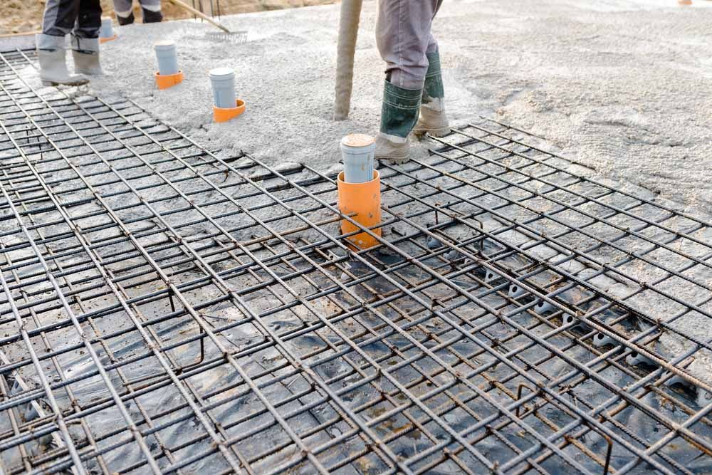 Man Pouring Concrete into a Concrete Foundation — NBM Constructions