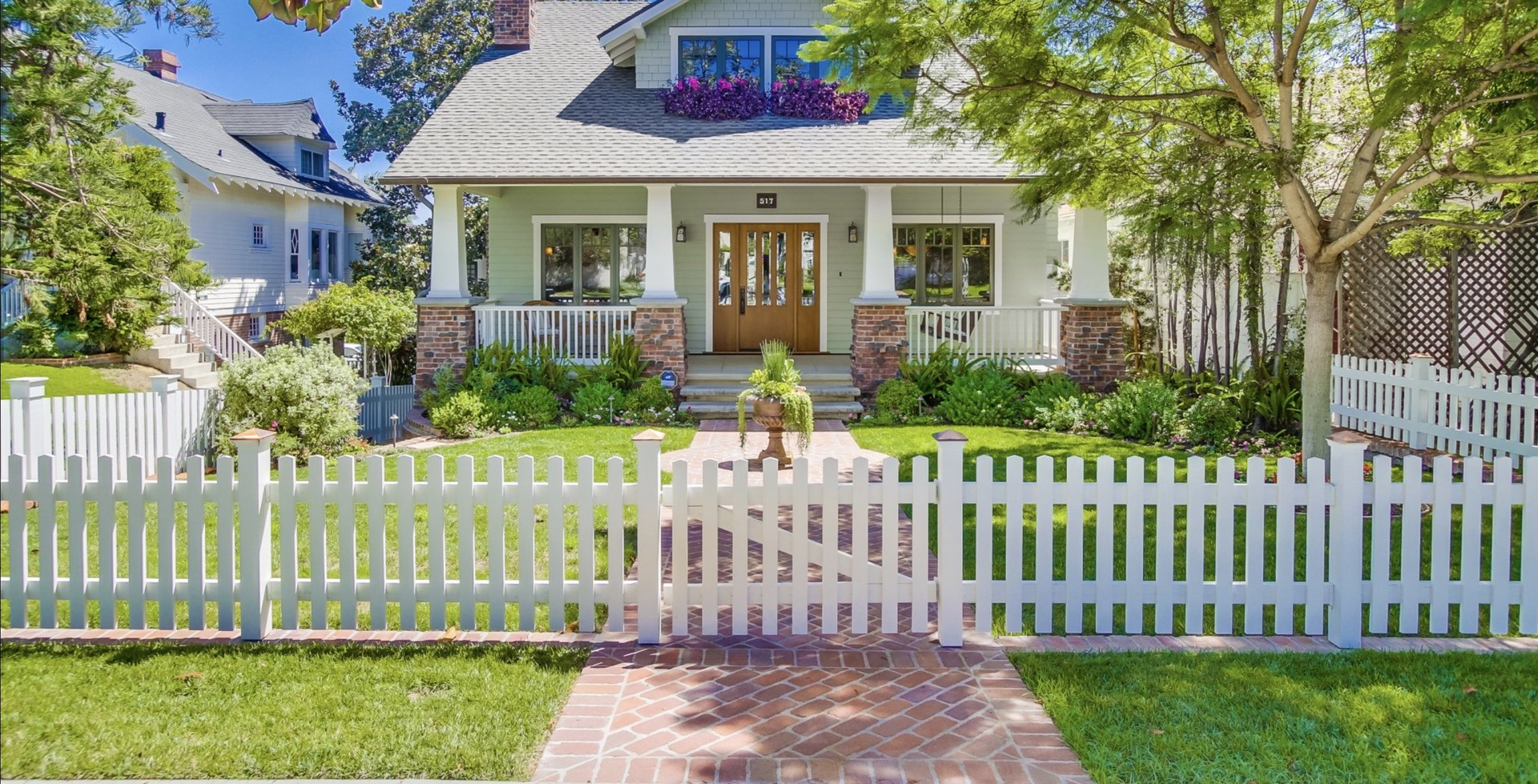 Suburban residential home with a white picket fence.