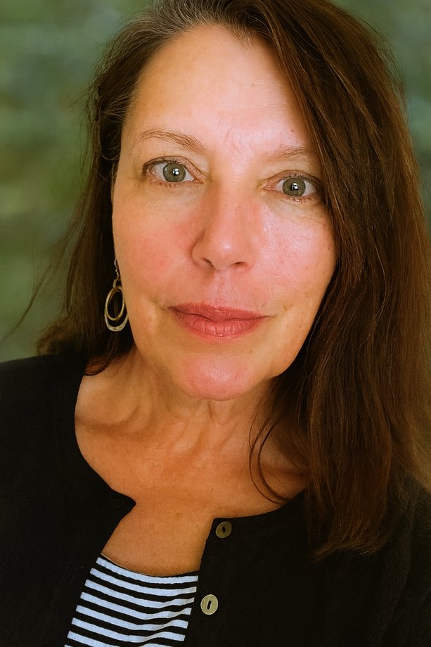 Woman with long brown hair, wearing a black cardigan over a striped shirt, and hoop earrings.