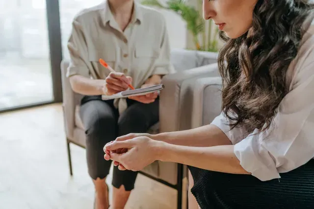 A man and a woman are sitting at a table talking to each other.