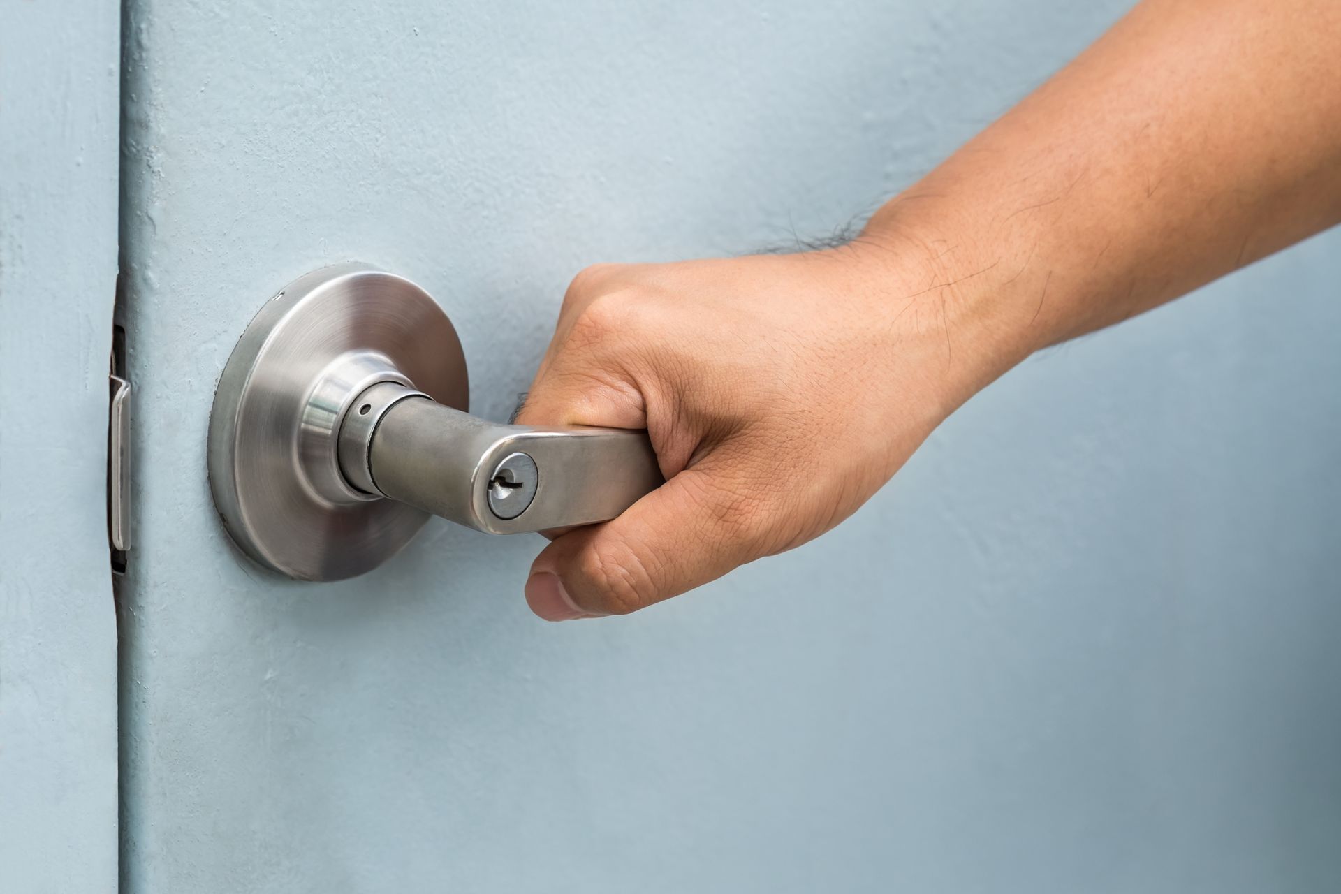 A close up of a person 's hand holding a door handle.