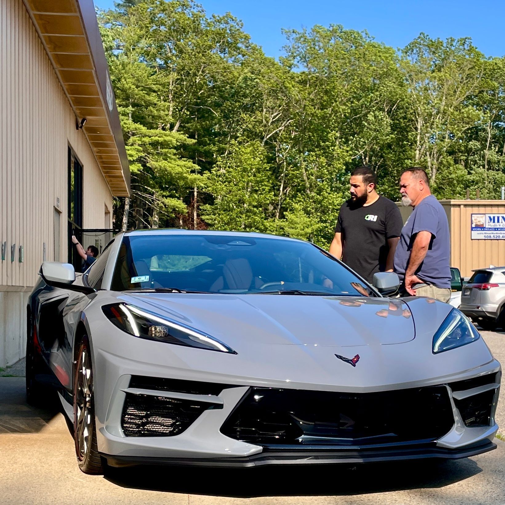 Two corvettes are parked next to each other in a garage.