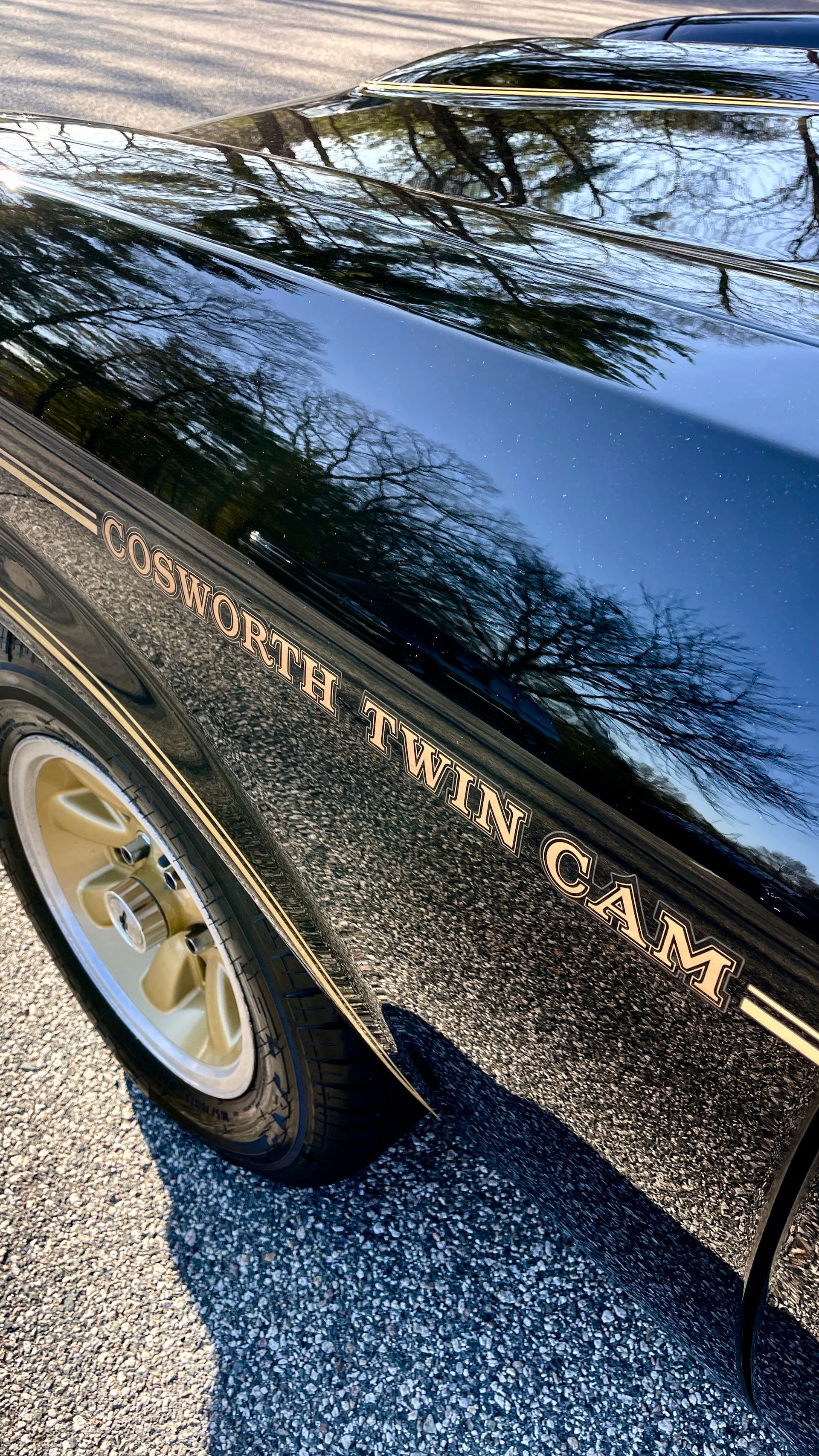 A close up of a black car parked on the side of the road.