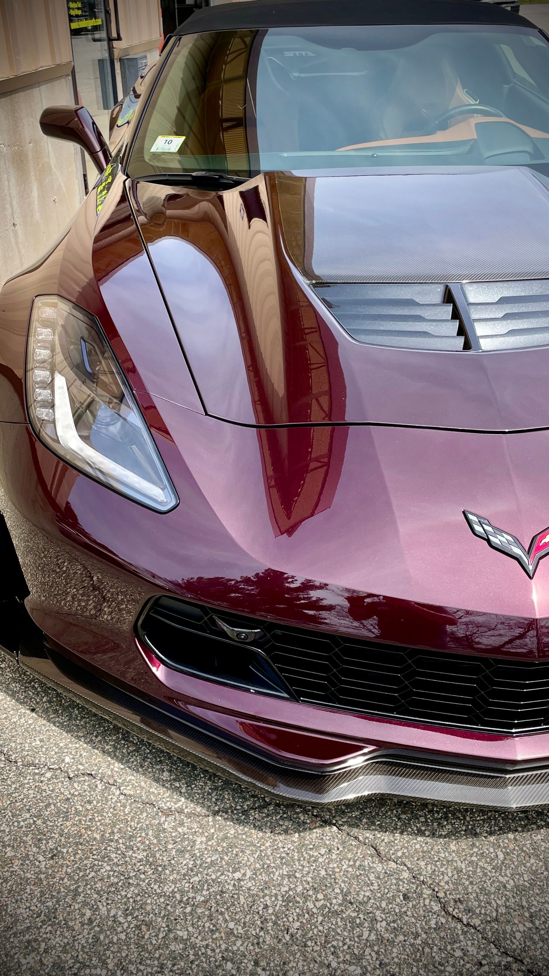 A red corvette convertible is parked on the side of the road.