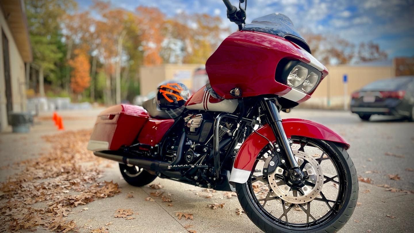 A red motorcycle is parked on the side of the road.