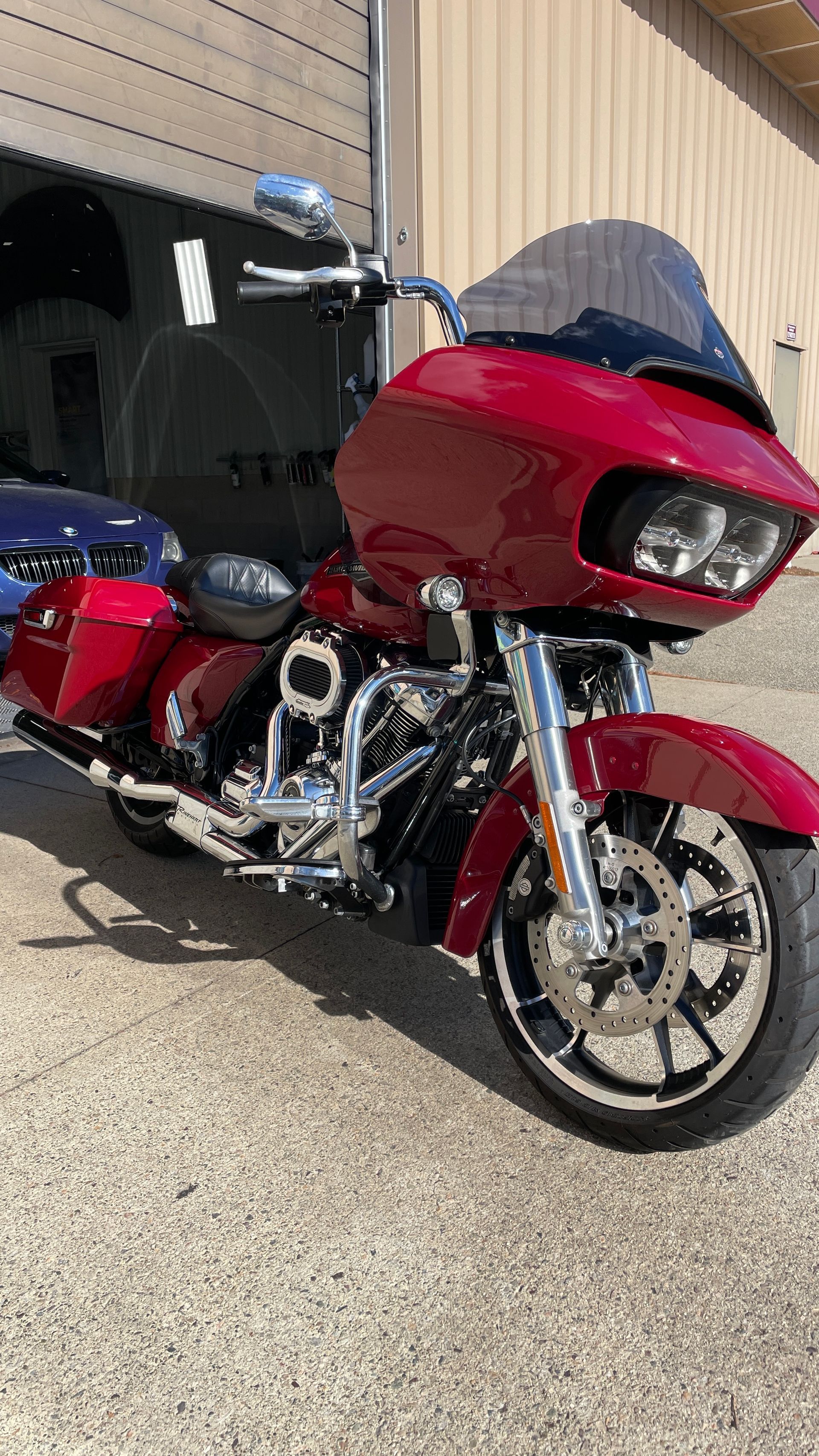 A red harley davidson road glide is parked in front of a building.