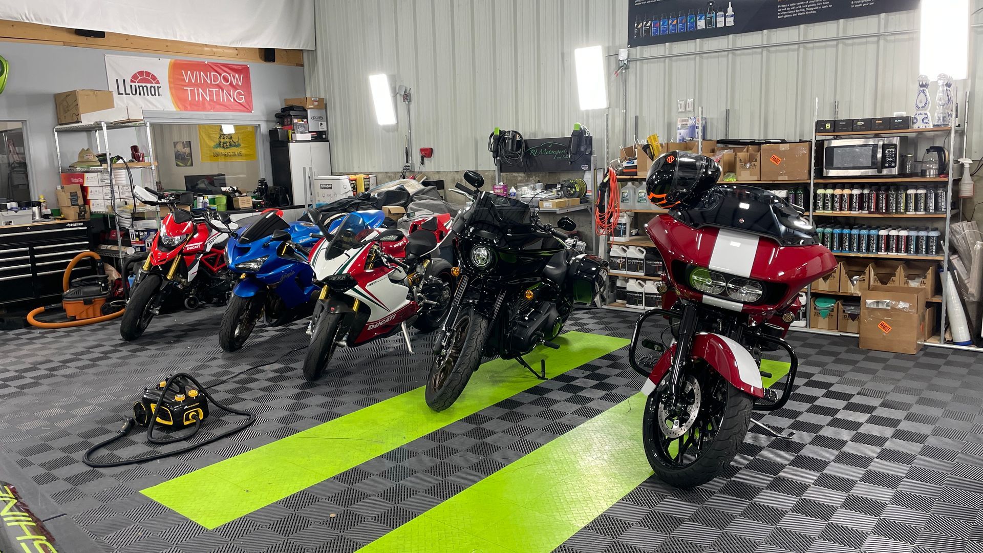 A row of motorcycles are parked in a garage.