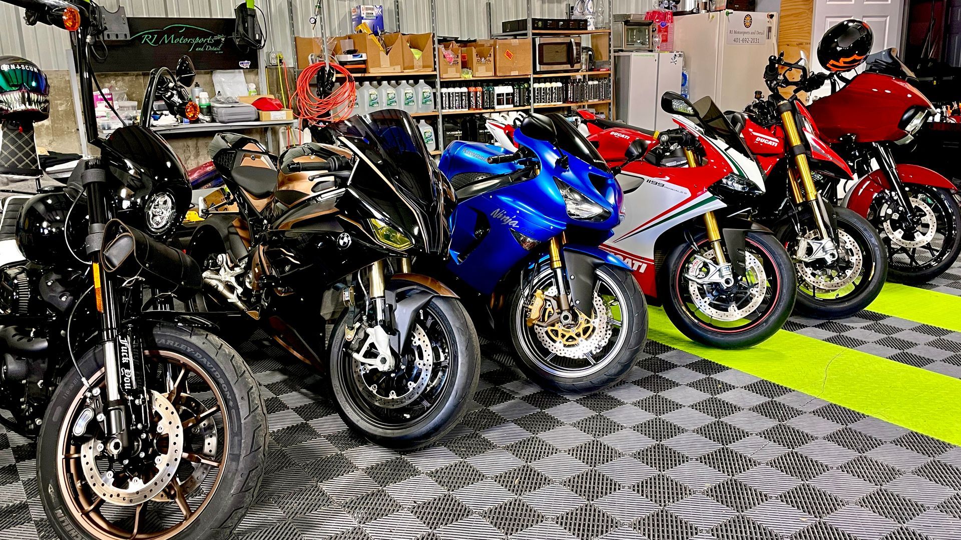 A row of motorcycles are parked in a garage.