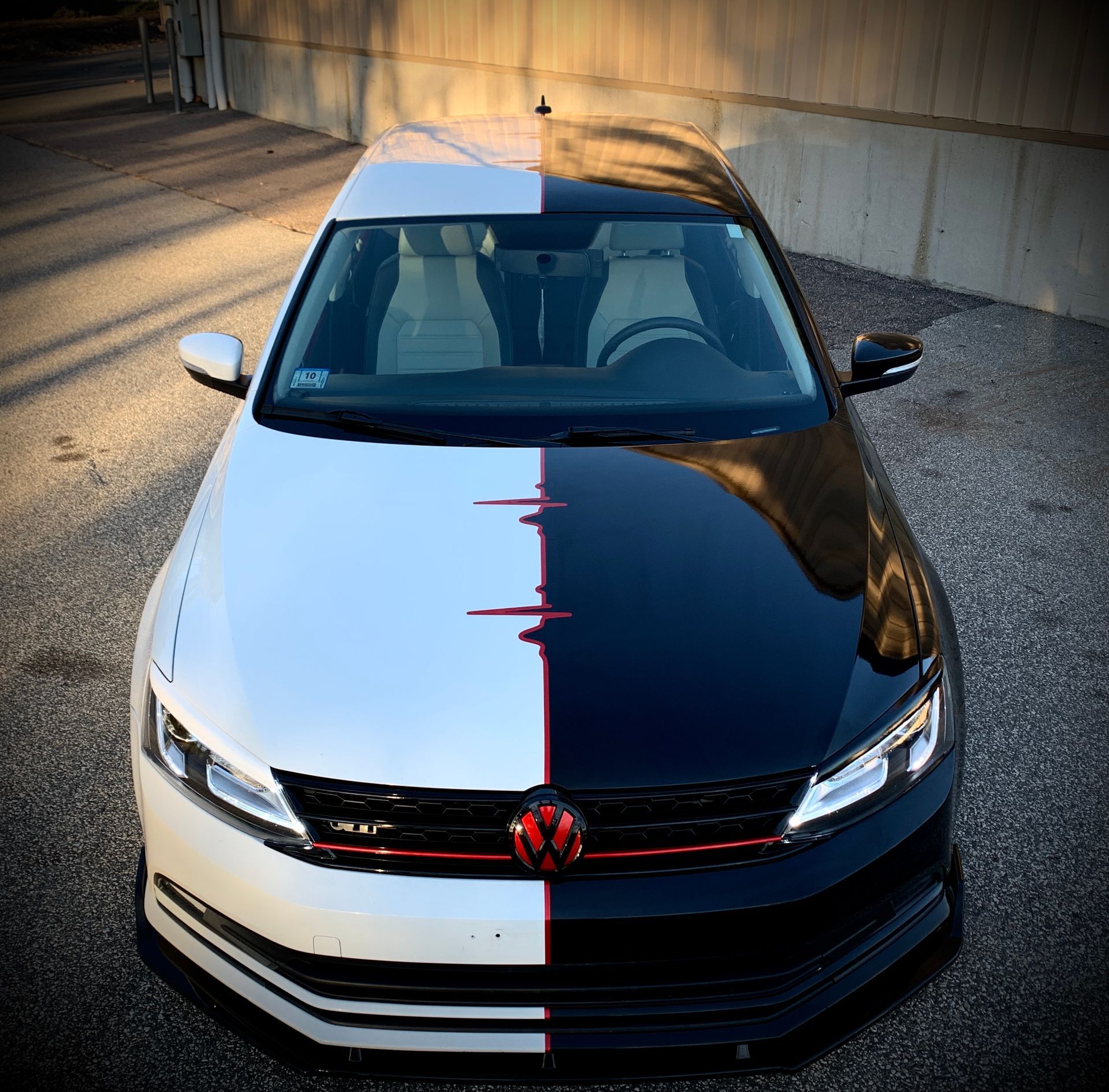 A black and white car with a red emblem on the front