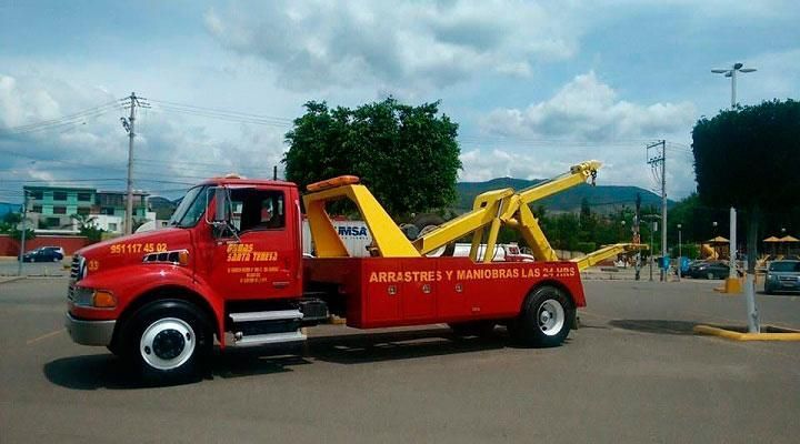 Una grúa roja y amarilla está estacionada en un estacionamiento.