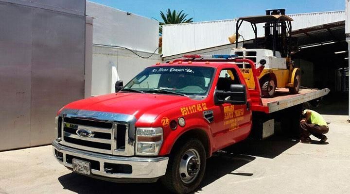 Una grúa roja con una carretilla elevadora en la parte trasera.