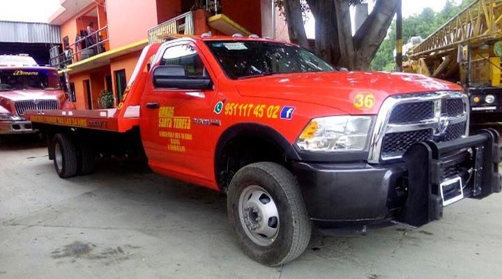 Una grúa roja está estacionada frente a un edificio.