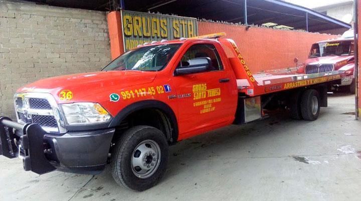 Una grúa roja está estacionada frente a un edificio.