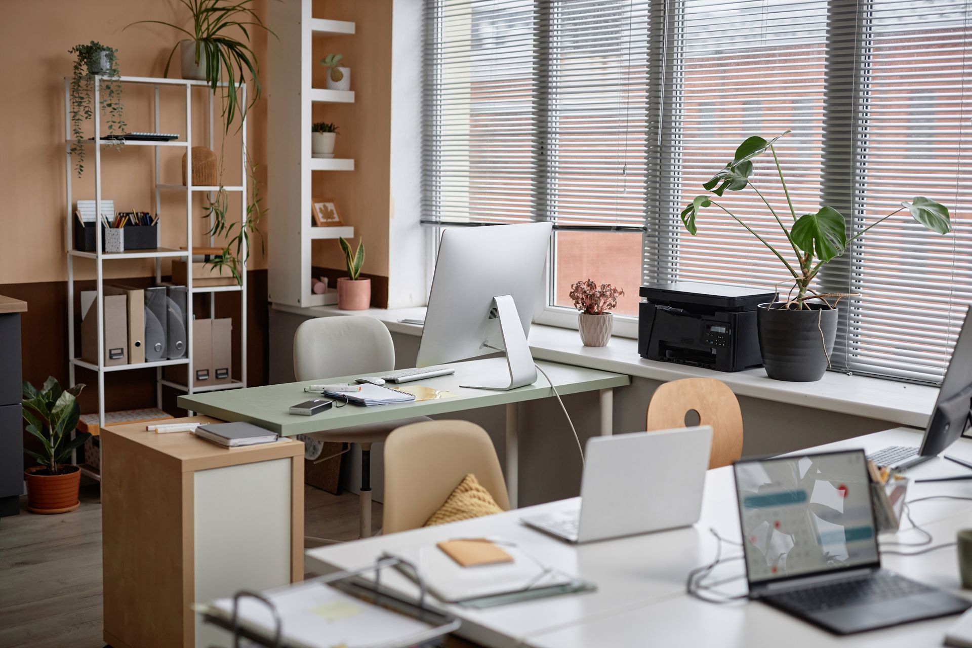 An office with a lot of computers and laptops on the desks.