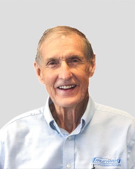 A man in a blue shirt is smiling for the camera.