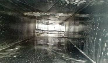 Inside of an HVAC duct, sprayed with cleaning solution, showing metal walls.