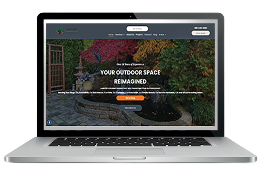 Laptop screen displays landscape design website, showcasing outdoor space with fountain and colorful foliage.