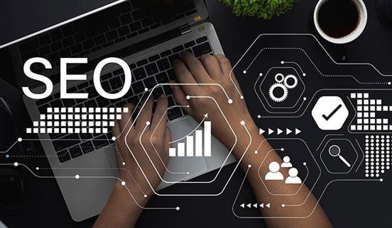 Person sketching UI design concepts in a spiral notebook with a pink pen.