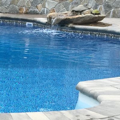 There is a waterfall in the middle of the pool.