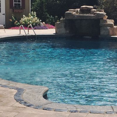 A large swimming pool with a waterfall in the background
