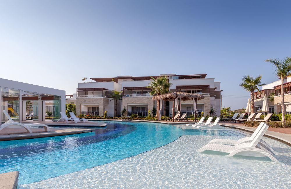 A large swimming pool surrounded by chairs and a building.