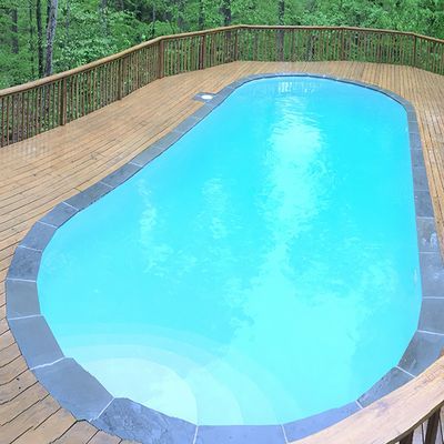 A large swimming pool with a wooden deck surrounding it