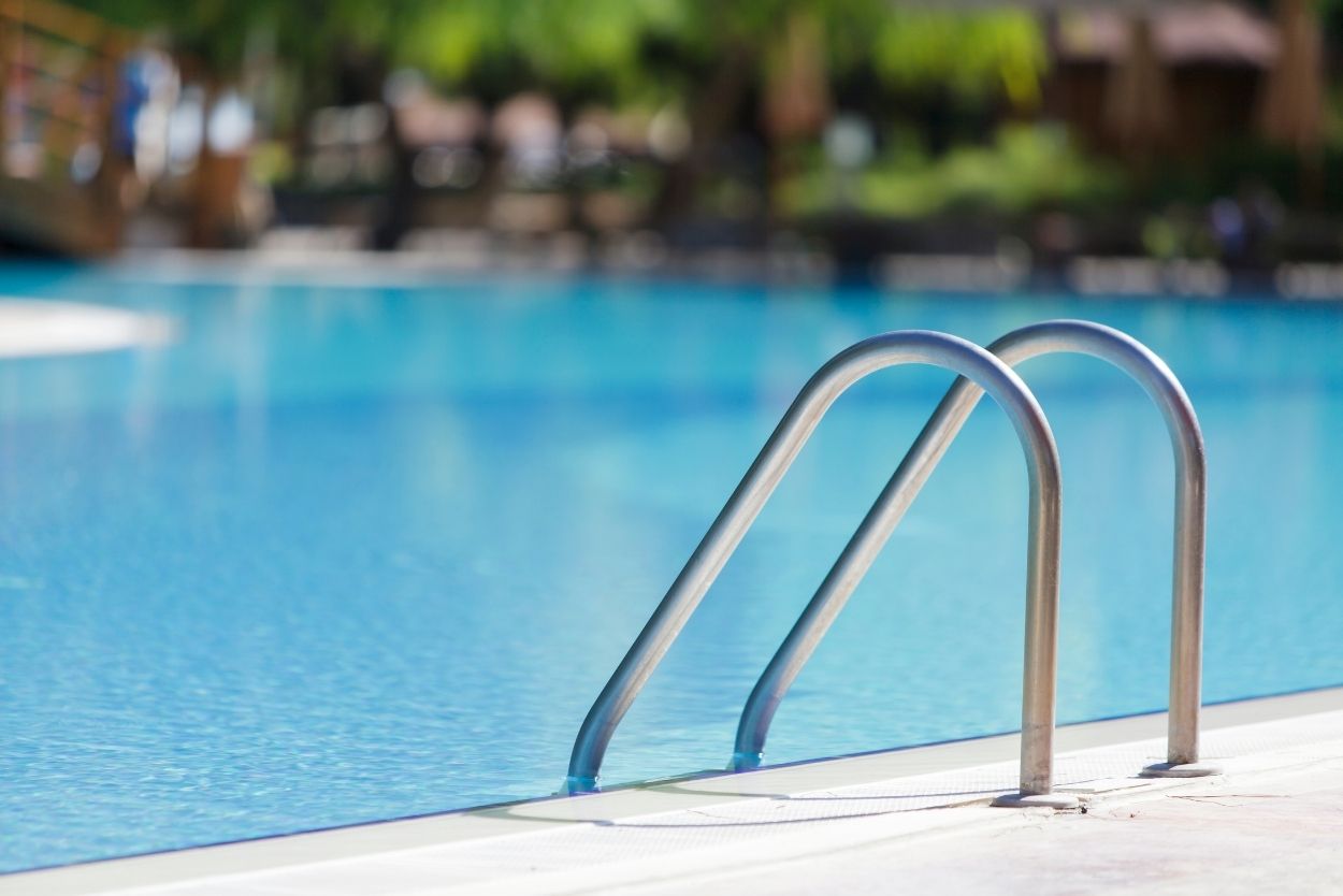 A stainless steel staircase leading to a swimming pool.