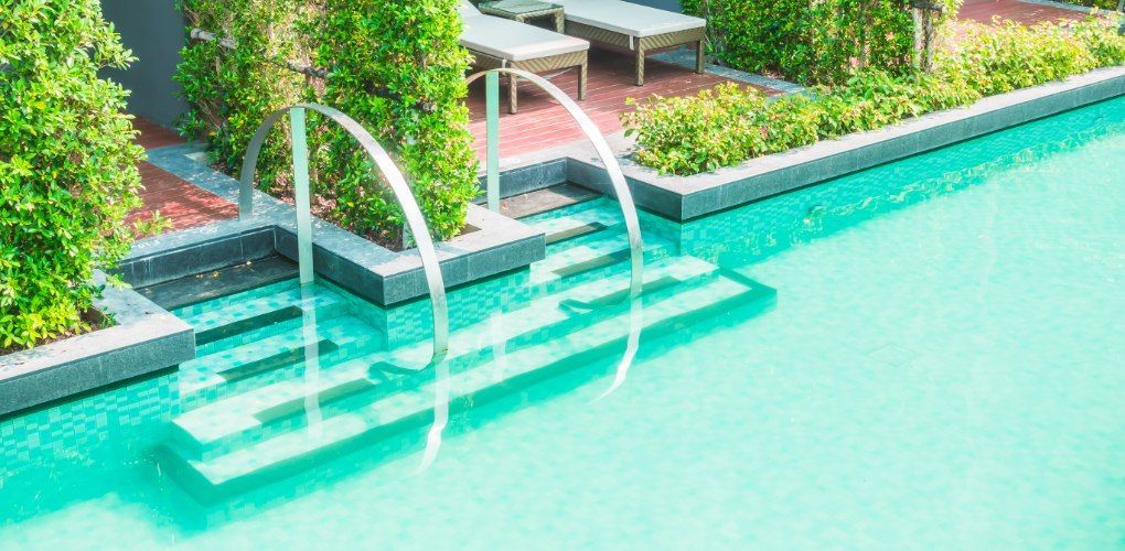 Aerial view of a backyard swimming pool with lounge chairs