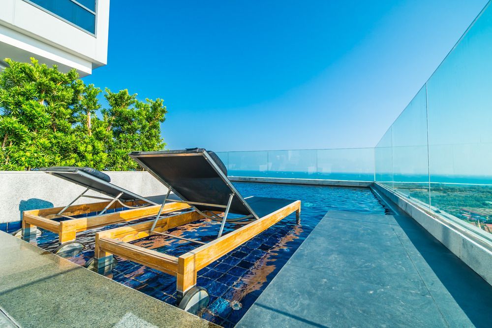 A swimming pool with a view of the ocean and a fence surrounding it.