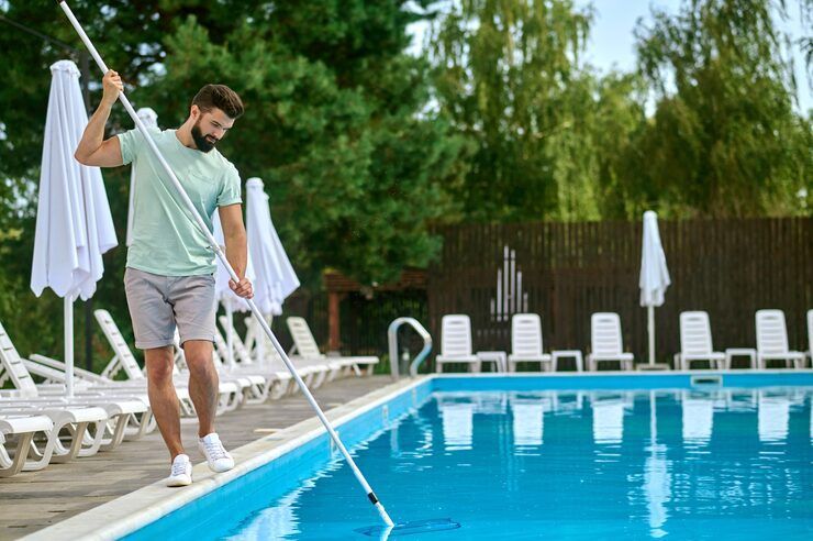 man cleaning the pool 