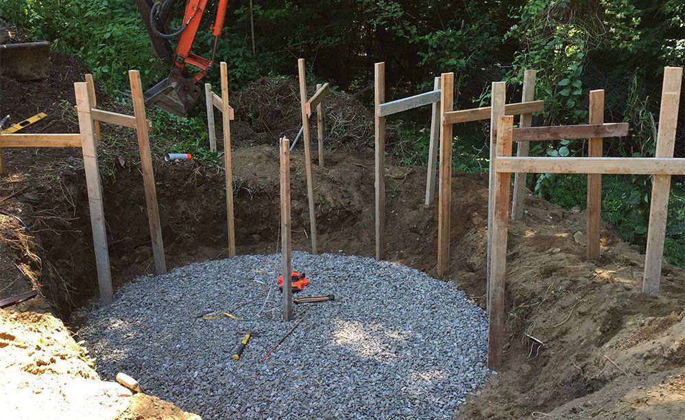 A wooden fence is surrounding a hole in the ground.