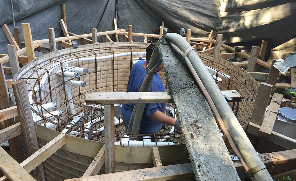 A man is standing in the middle of a building under construction.