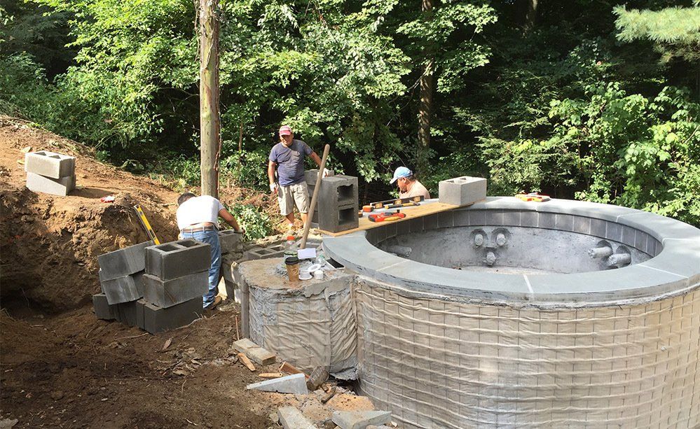 A group of men are working on a large brick structure.