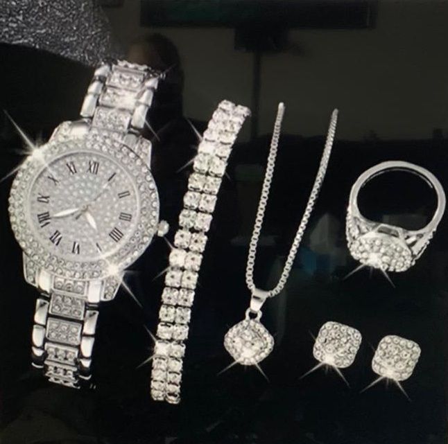 Een horloge met Romeinse cijfers wordt omringd door sieraden