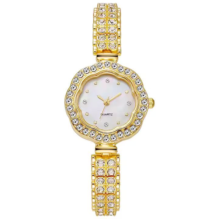 Een gouden horloge met een witte wijzerplaat en strass steentjes eromheen