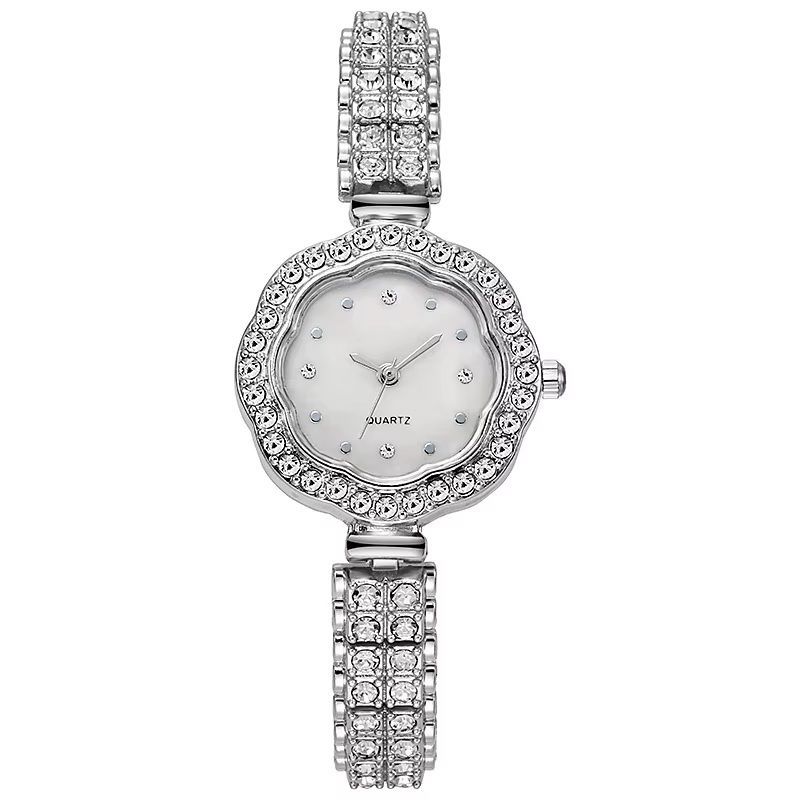 Een zilveren horloge met een witte wijzerplaat en strass steentjes op de band