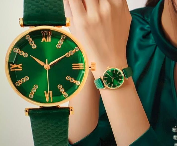 Een vrouw draagt een groen horloge met Romeinse cijfers