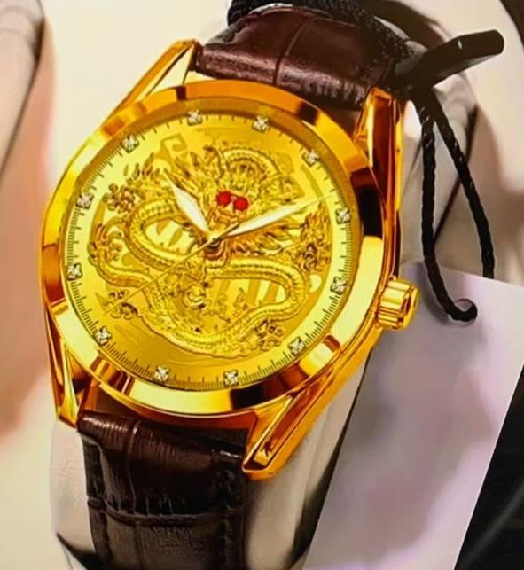 Een gouden horloge met een draak op de wijzerplaat