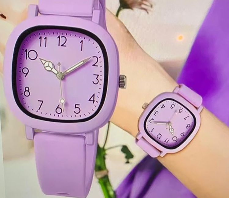 Een persoon draagt een paars horloge om zijn pols
