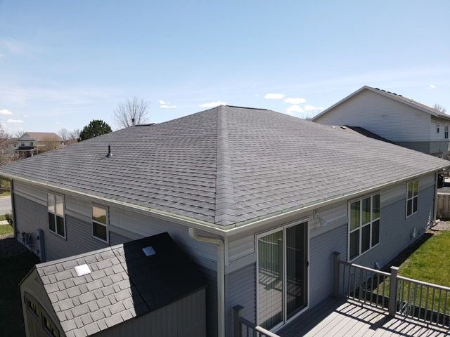 An aerial view of a house with a gray roof and a deck.