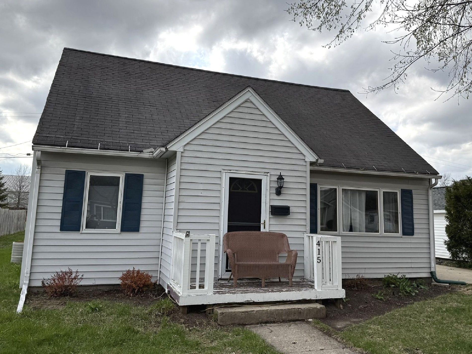 A white house with a brown roof and a driveway.