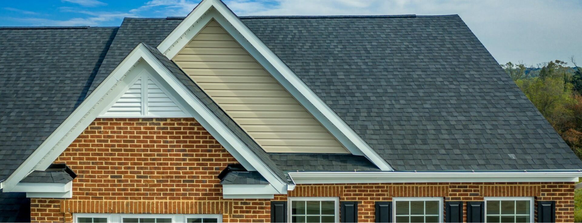 Brick house with gray roof and white trim.