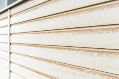 A close up of a white siding with brown stains on it.