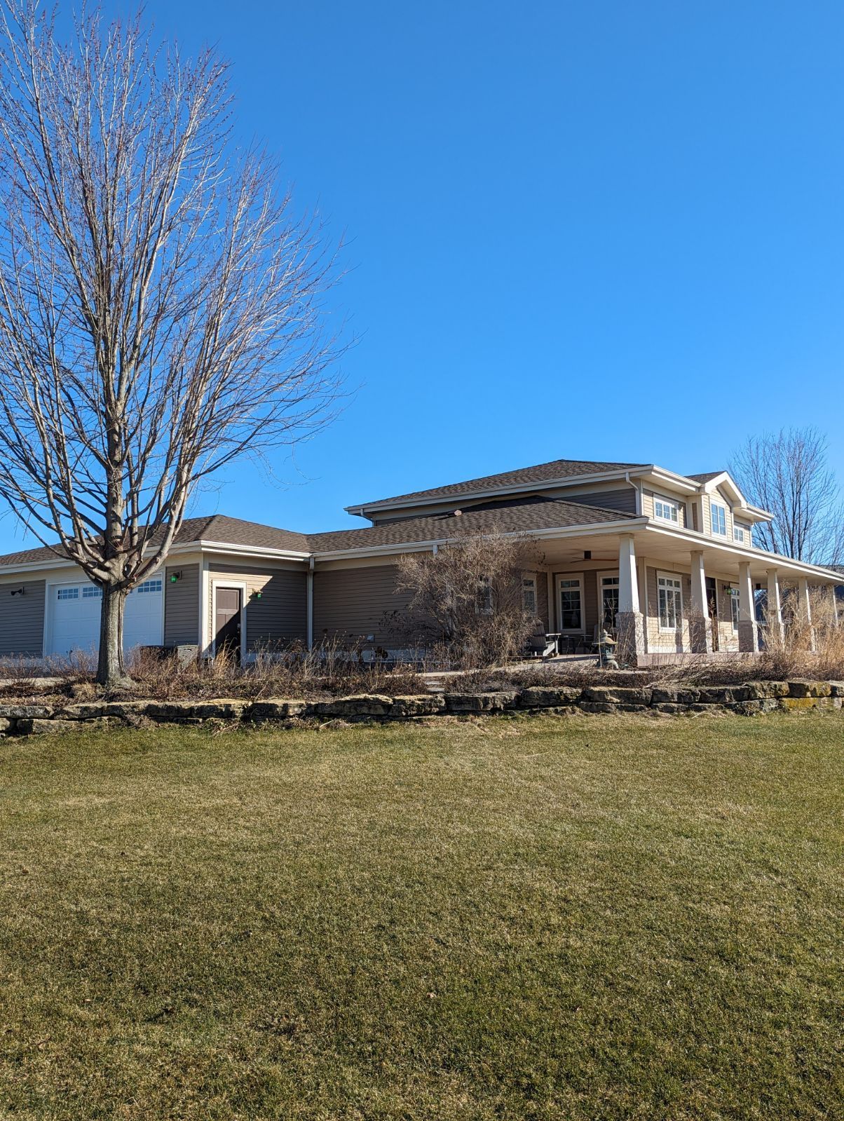 A large house is sitting on top of a lush green field.