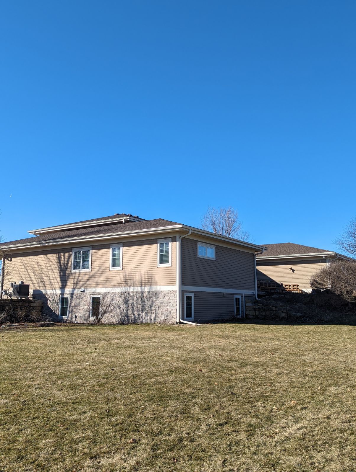 A large house is sitting in the middle of a grassy field.