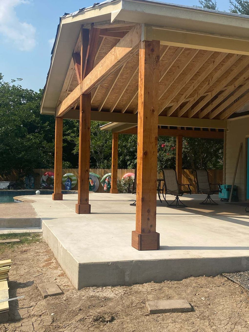 A wooden structure is being built next to a pool.