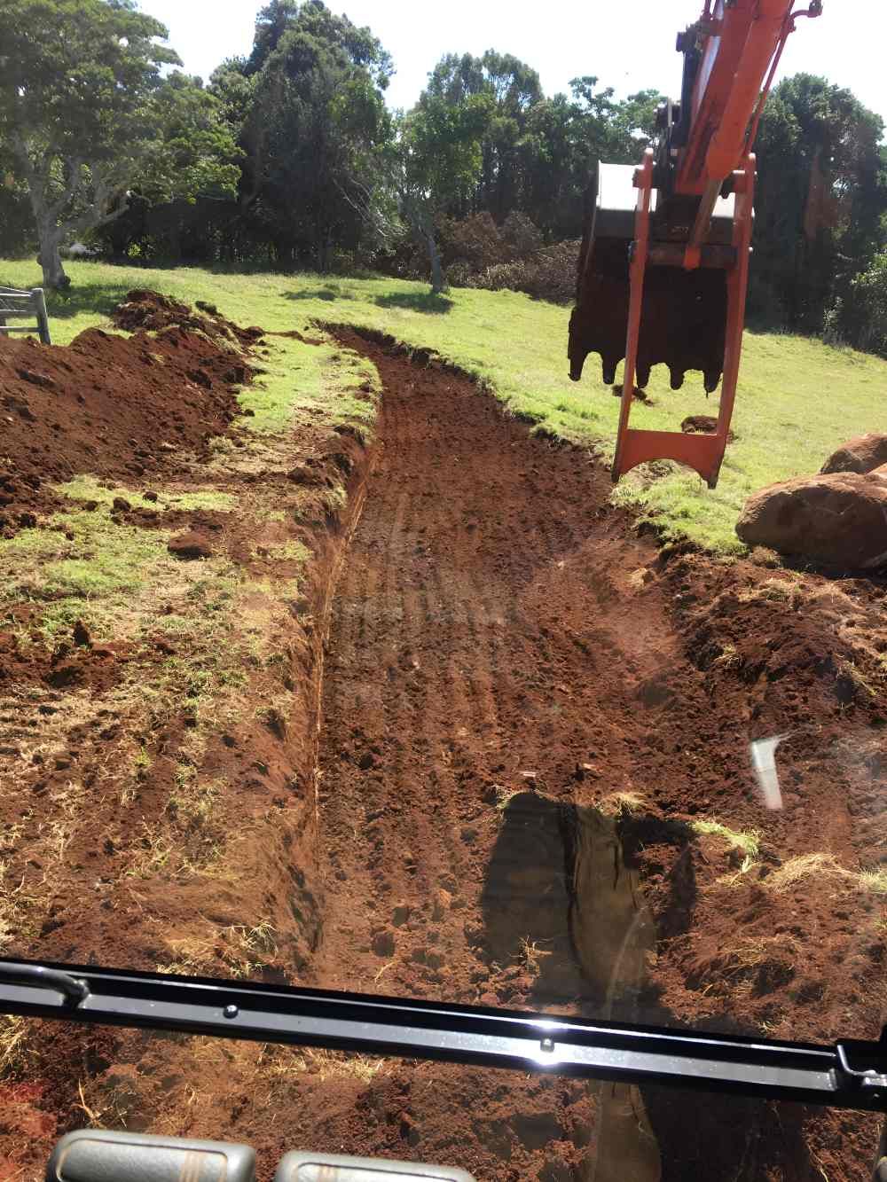 An Excavator is Digging a Hole in the Dirt in a Field — Byron Earth & Road in Ballina, NSW
