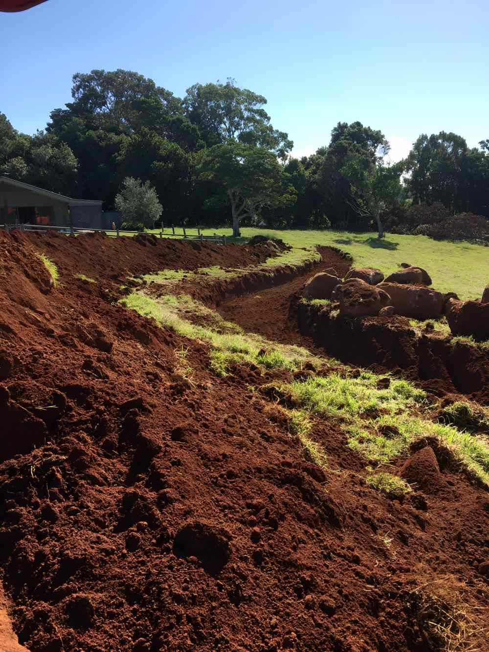 A Large Pile of Dirt in a Field With Trees in the Background — Byron Earth & Road in Byron Bay, NSW