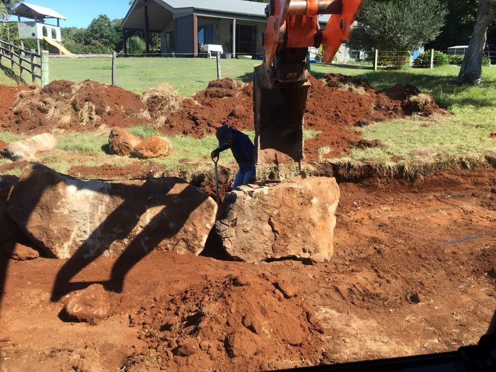 A Man is Digging in the Dirt in Front of a House — Byron Earth & Road in Wardell, NSW