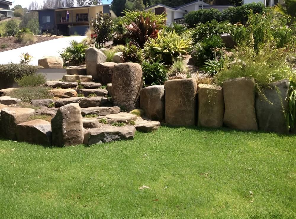 A Lush Green Lawn With a Stone Wall and Stairs — Byron Earth & Road in Wardell, NSW